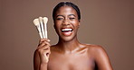 Laughing, brush or face of black woman in studio for glow, makeup or skincare portrait. Happy, funny joke or African female model on brown background with beauty cosmetics, confidence or facial tools