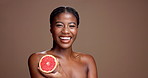 Laugh, face or black woman in studio with grapefruit for brightening, beauty or space. Portrait, smile or happy model on brown background with tropical citrus for healthy glow, vitamin c and skincare