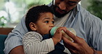 Relax, bottle and father with baby in home for feeding, bonding or nap time in afternoon. Love, care and dad with toddler for drinking milk for growth, development or nutrition in living room.