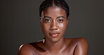 Face, confident and woman with glow, studio or bodycare with cosmetics, healthy skin or dermatology. Gray background, black person and pride for shine, soft and self care with treatment and wellness
