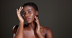 Glow, skincare and hands with face of black woman in studio for beauty, dermatology and self care. Mockup space, hydration and aesthetic with female model on dark background for shine and grooming