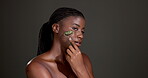 Jade roller, beauty and face of black woman in studio for lymphatic drainage, skincare and detox. Facial tools, glow and collagen with person on dark background for massage and holistic treatment 