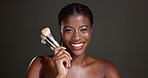Black woman, makeup brush and face with smile in studio for beauty, glow and pride by background. African girl, cosmetics and happy in portrait for foundation, transformation or mockup space in Kenya