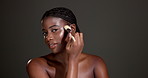 Beauty, face and makeup brush with black woman in studio to apply concealer or foundation. Aesthetic, contouring and cosmetics with African model on dark background for dermatology or skincare