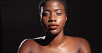 Face, beauty shine and African woman on black background with makeup, confidence and healthy skin. Dermatology cosmetics, facial or proud female person in studio with glow, mockup space and wellness