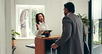 Lobby, tablet and hotel concierge with man for accommodation, internet booking and business trip. Conversation, tech and receptionist with guest for hospitality, service or corporate travel check in