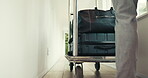 Luggage, help and trolley with person in hotel for bellhop assistance, guest escort and welcome service. Suitcase, concierge and bag porter with legs of employee for hospitality, checkout and walking