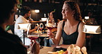 Couple, night or drinking wine in restaurant with date for romantic dinner, anniversary or occasion. Man, woman or tasting alcohol in late evening with meal for fine dining, romance or rendezvous