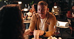 Smile, couple and holding hands in restaurant for love, date and connection together with partner. Happy man, woman and romance at dinner for relationship, laughing and talk for anniversary at night