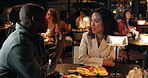 Talking, couple and happy on date in restaurant, night and romance on weekend, together and alcohol. Bonding, man and woman with meal in diner, evening and conversation for relationship or wine