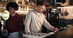 Bartender, men and tablet at pub for POS sales, inspection and inventory checklist at small business service. People, bar manager and digital tech with app for menu, teamwork and hospitality review