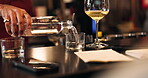 Pouring, water and wine with hand of bartender in restaurant for hospitality, refreshment or service. Alcohol, bottle and nightlife with person at counter in pub for beverage or drinks order closeup
