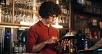 Order, reading and tablet with bartender in restaurant at night for hospitality or service. App, bill and checkout with waiter in cafe or coffee shop for ecommerce, invoice or online transaction