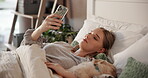 Online, pet and woman with phone in bedroom, texting and chilling with puppy in home, relax and web. Calm, person and resting with dog on bed, browsing and bonding with canine in house or mobile app