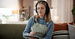 Headphones, tablet and woman on sofa in home with networking, relax and listening to music. Happy, stylus and female person drawing on digital technology with streaming playlist in living room.