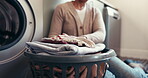 Folding, laundry and person with chores, home or organizing clothes in apartment, basket or routine. Spring cleaning, hands and arrangement of tidy linen, sorting and cleaner with finished housework