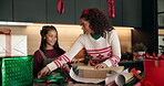 Help, Christmas and gift with family and wrapping paper for holiday season, celebration and bonding. Present, festive tradition and package with mother and child in home for decoration and box