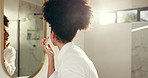 Woman, skincare and cream by bathroom mirror with application, moisturizer and morning routine in home. African person, lotion and product for hydration, collagen or dermatology benefits in house