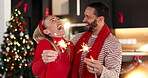 Laugh, couple and sparkler for Christmas in home, festive holiday and celebration together. Xmas, man and funny woman with fireworks in living room for new year event, December season and party