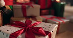 Bow, Christmas present and wrapping paper with boxes in living room of home for festive celebration. Holidays, gift and ribbon with wrapped package on floor in apartment for December or winter season