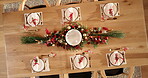 Christmas, celebration and table setting with decorations in home for holiday event, cutlery or party. Above, thanksgiving and xmas arrangement in dining room with tableware, dinner or festive season