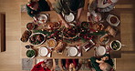 Dishing, family and christmas dinner in home for festive celebration, event or party together. Food, top view and people in dining room with carving meat for gourmet meal, feast or supper for xmas.