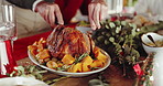 Person, hands and dining table with chicken for christmas celebration or holiday feast in home. People, cut and meal with vegetables for thanksgiving dinner, family lunch or eating together in house