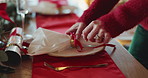 Christmas, hands and set table with napkin for dinner preparation, holiday celebration or decoration. Woman, plate and cutlery for xmas in home dining room, festive season and hospitality for event