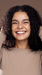 Shake, curly hair and face of woman in studio for beauty, salon transformation and self care. Natural texture, glow and keratin shine with female model on brown background for growth and shampoo