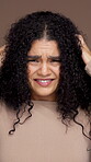 Face, woman and worry with hair care in studio for dry texture, split ends and breakage crisis. Confused, female person and curly hairstyle fail, growth problem and scalp issues on brown background
