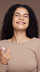 Spray, beauty and face of woman in studio for natural makeup, self care and glow. Aesthetic, shine and cosmetology with portrait of model on brown background for setting product, smile and grooming