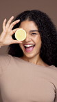 Skincare, lemon and face of woman in studio for natural, health and facial glow with hydration. Organic, happy and portrait of female person with citrus fruit for brightening by brown background.