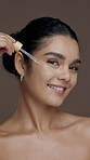 Serum, beauty and face of woman in studio for skincare, vitamin c dropper or self care cosmetics. Hyaluronic acid, collagen benefits and facial product with person on brown background for dermatology