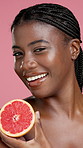 Skincare, grapefruit and face of black woman in studio with natural, cosmetic or facial routine. Health, beauty and portrait of African person with citrus fruit for dermatology by pink background.