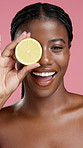 Face, beauty and black woman with lemon for skincare, natural wellness or skin health. Portrait, cosmetics or happy model with fruit for vitamin c, organic benefits or detox on pink studio background