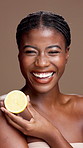 Black woman, face or skincare with lemon for health detox or vitamin C on a brown studio background. Portrait, female person or happy model with smile or natural organic fruit for citrus acid or diet