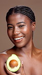 Beauty, avocado and face of black woman in studio with natural, organic or cosmetic routine. Portrait, skincare and African female person with fruit for moisturizing dermatology by brown background.