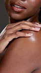 Hands, closeup or woman in studio with body care, treatment or skin hydration. Shine, shoulder or African female person isolated grey background with smooth texture, beauty glow or hygiene cosmetics