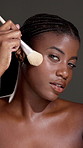 Brush, makeup and face of black woman with glow in studio with beauty, confidence and facial routine. Self care, foundation and portrait of African person with tool for cosmetology by gray background