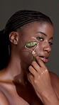 Skincare, jade roller and face of black woman in studio for lymphatic drainage, self care or detox. Facial tools, holistic treatment and natural beauty with person on dark background for circulation