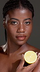 Skincare, face and black woman in studio with lemon for natural, organic or facial glow routine. Health, portrait and African person with citrus fruit for brightening dermatology by gray background.
