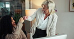 Computer, fist bump and business women with success, congratulations or achievement in office. Mature mentor, feedback and financial advisors with celebration for profit growth, goal or teamwork