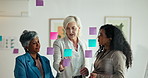 Sticky notes, office and business women by glass for planning, brainstorming and project ideas. Corporate, teamwork and people in meeting, discussion and talking for strategy, schedule and tasks 