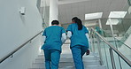 Hospital, team and back of nurse on stairs for consulting, feedback and diagnosis results. Healthcare, clinic and people walking with tech in discussion for medical advice, teamwork and research
