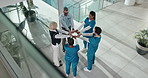 People, medical team and fist bump with hands together in circle or huddle above in hospital. Group, healthcare workers or union with formation for collaboration, mission or unity in solidarity