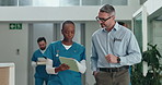 Hospital, lobby and nurse with doctor on tablet for consulting, feedback and diagnosis results. Healthcare, clinic and people in discussion walking on tech for medical research, teamwork and advice