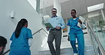 Hospital, stairs and doctor with nurse for healthcare advice, planning surgery or tablet app. Folder, database and tech with medical expert or people walking for collaboration, teamwork or low angle