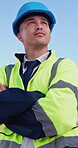 Arms crossed, building and thinking with construction worker man outdoor on blue sky for development. Architecture, smile and vision with happy property developer on site for project management