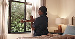 Black woman, wake up and stretching on bed in morning, routine and wellness with circulation in home. African person, back and warmup arms for health, muscle and perspective by window at house