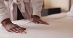 Hands, woman and making bed in hotel room for morning routine, maintenance and getting ready. Tourist, hospitality and cleaning in bedroom of resort for travel, vacation and holiday with robe